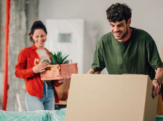 People moving boxes inside house